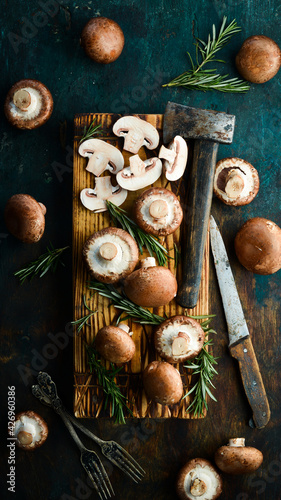 Fresh champignon mushrooms sliced on a wooden board. Rustic style. Top view.