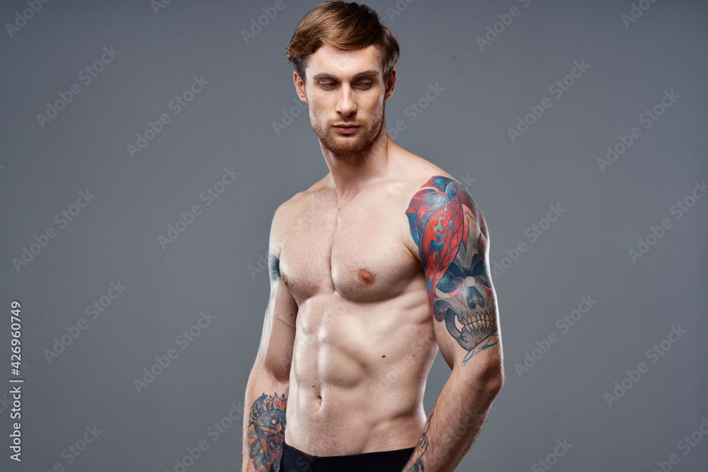 sporty man with pumped up press tattoo on his arms macho cropped view