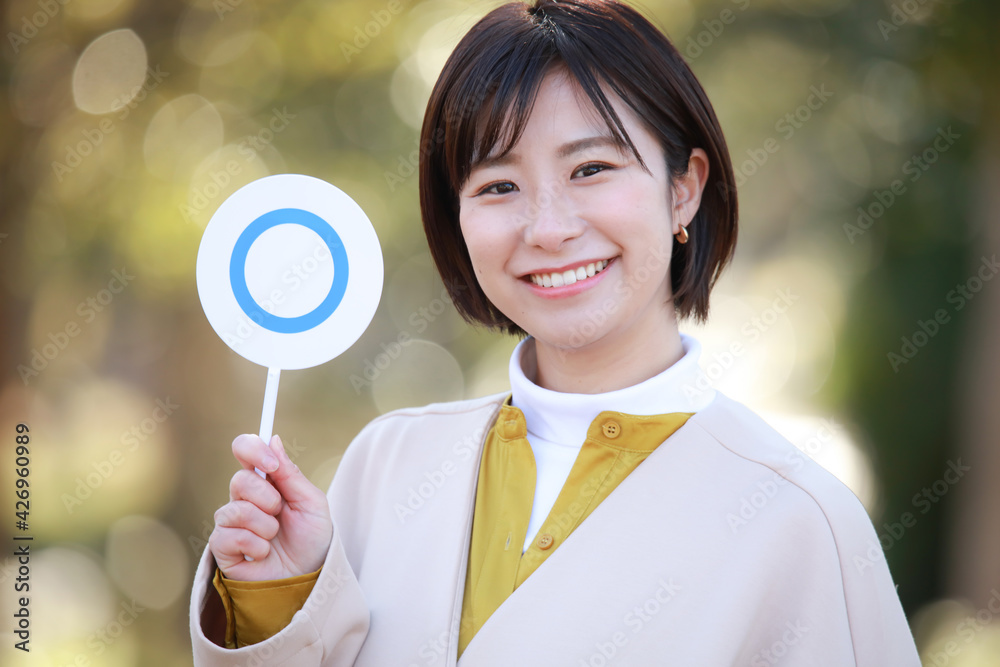 〇札を持つ女性