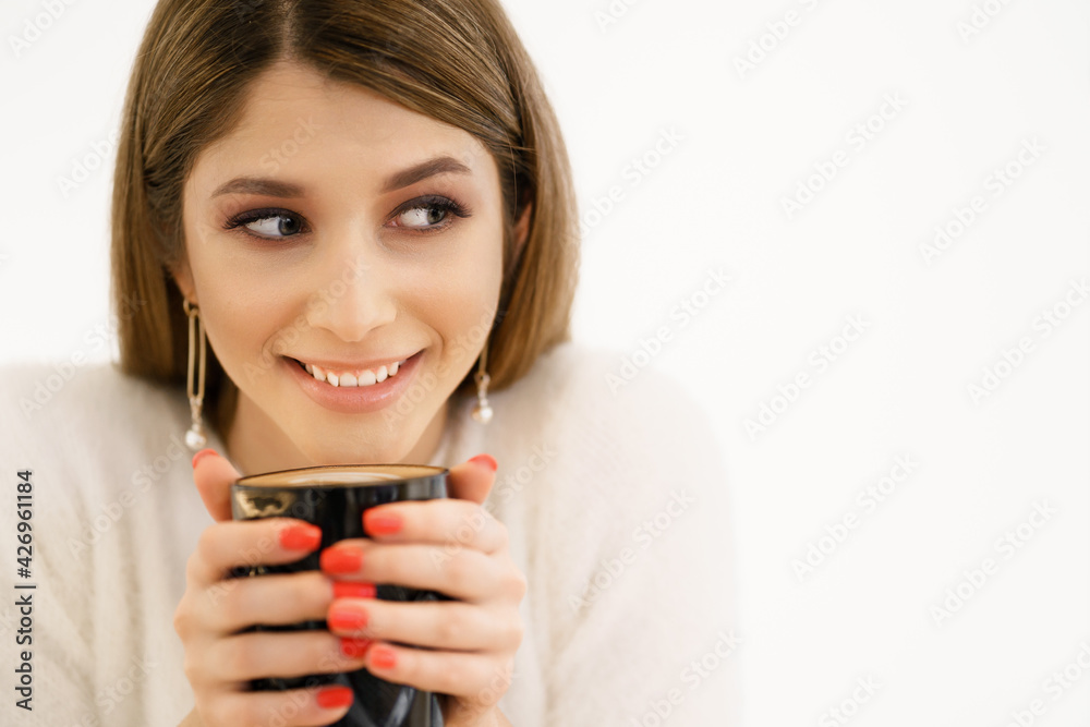 Young smiling beautiful happy woman with long hair enjoying cappuccino on white background. Beauty Woman enjoying Coffee. Cup of Hot Beverage. Young smiling beautiful happy woman with long hair enjoying cappuccino on white background. Beauty Woman enjoying Coffee. Cup of Hot Beverage.