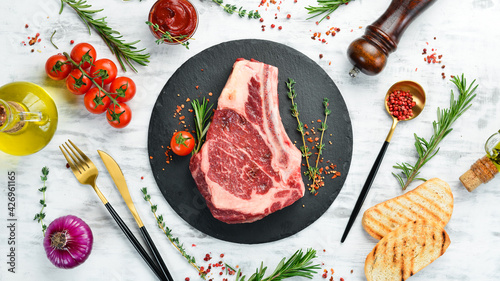 Canvastavla Grilled beef ribeye steak on the bone on a white wooden background