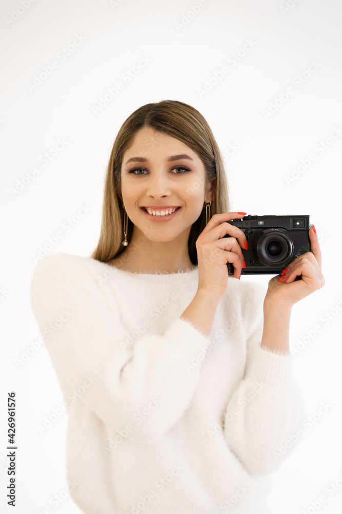 Beautiful Hipster woman taking photos with black retro film camera on white background. Close up. Indoor. Warm color. Blogger Beautiful Hipster woman taking photos with black retro film camera on white background. Close up. Indoor. Warm color. Blogger
