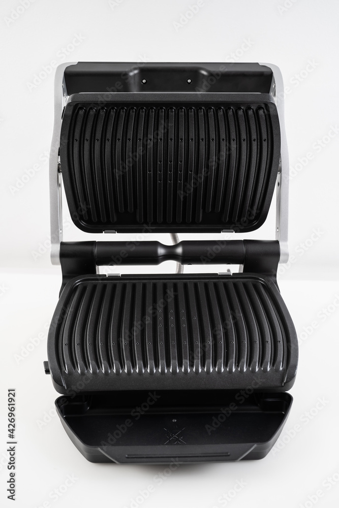electric grill with open lid. appliance for cooking in everyday life. Made of stainless steel, special non-stick coating. healthy food. food without oil and fat. electric grill with open lid. appliance for cooking in everyday life. Made of stainless steel, special non-stick coating. healthy food. food without oil and fat.