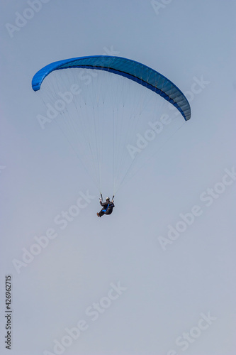 Paraglider flying high up in the sky