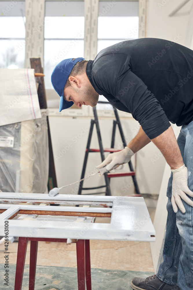 Young adult man painting on a DIY budget renovation of his new home apartment. Young adult man painting on a DIY budget renovation of his new home apartment.