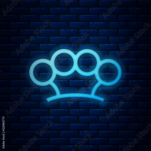 Glowing neon Brass knuckles icon isolated on brick wall background. Vector