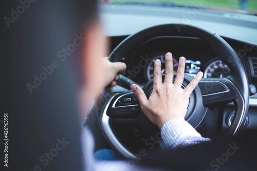 Obraz na plátně Close up image of inside the car of the hand pressing the horn on the steering wheel