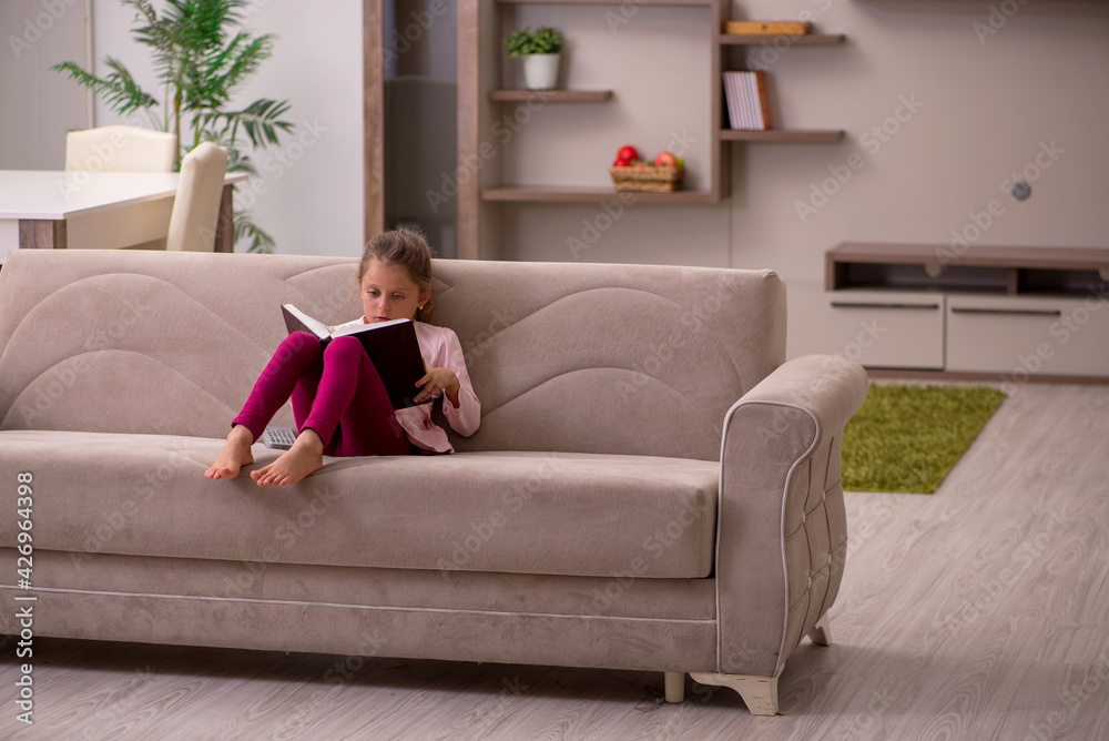 Small girl reading book at home Small girl reading book at home