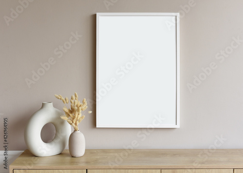 Fototapeta Blank picture frame mockup on gray wall. White living room design. View of modern scandinavian style interior with artwork mock up on wall. Home staging and minimalism concept