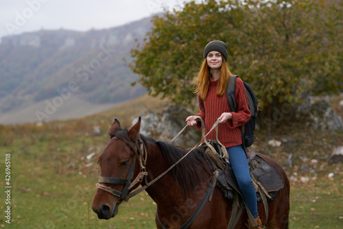 woman hiker with a backpack rides a horse in the mountains nature travel © SHOTPRIME STUDIO