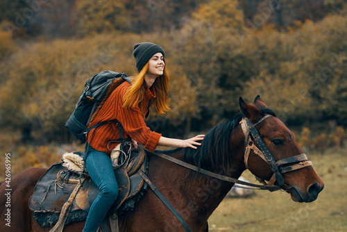 cheerful woman hiker riding a horse adventure mountains fresh air