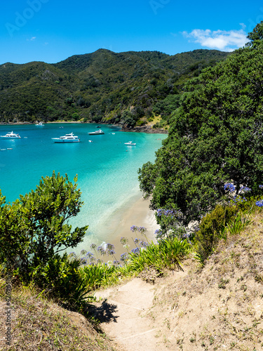 Blue water and white sand of Opourua Bay and Oke Bay and Cape Brett Lighthouse and Cape Brett Hut in Rawhiti New Zealand
