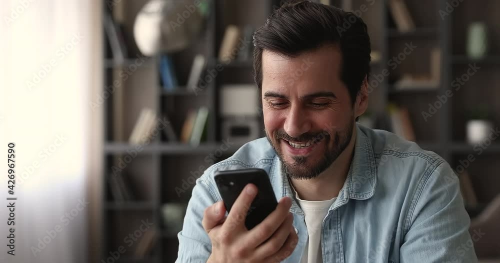 Head shot smiling young man recording audio message on mobile phone, sending voice mail, using virtual assistant application web surfing information or translating text, distant communication concept.
