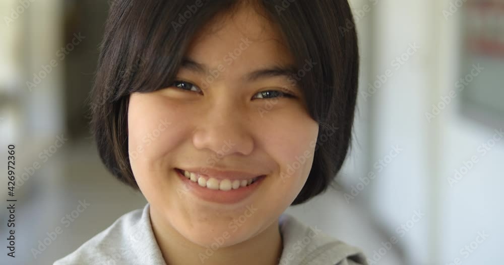 Slow motion close up scene of a cute young Asian teenage high school student girl is smiling happily. Slow motion close up scene of a cute young Asian teenage high school student girl is smiling happily.