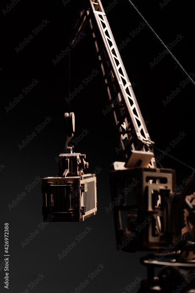 Port crane made of wood on a black background