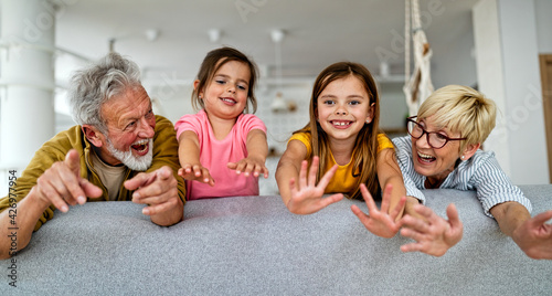 Grandchildren having fun at home while playing with their grandparents