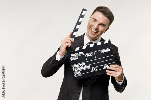 Young happy employee business corporate lawyer man in classic formal black grey suit shirt tie work in office hold classic black film making clapperboard isolated on white background studio portrait