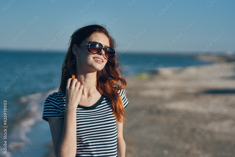 a traveler in sunglasses and a t-shirt is resting on the beach near the sea in the mountains a traveler in sunglasses and a t-shirt is resting on the beach near the sea in the mountains