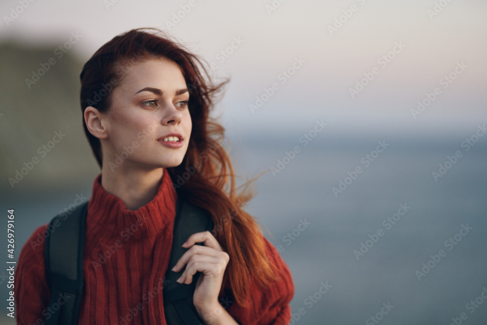 Traveling with a backpack on his back in a red sweater in the mountains near the sea in nature Traveling with a backpack on his back in a red sweater in the mountains near the sea in nature