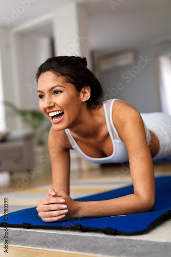 Fitness, sport, training and lifestyle concept. Smiling woman doing exercises at home