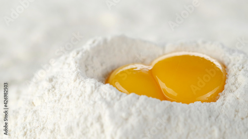 eggs in pile of flour close up. a bunch of flour with raw eggs