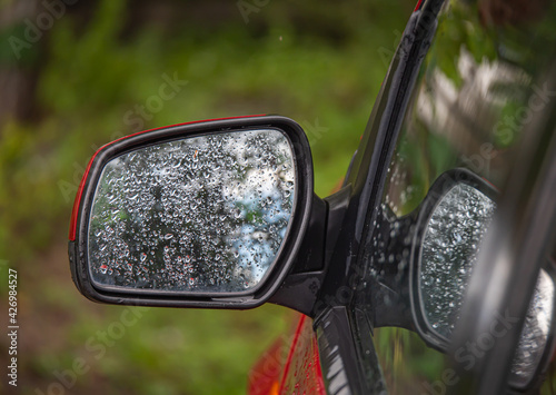 car side rear view mirror with rain drops