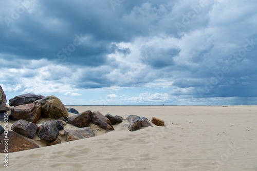 Stones on empty beach with a cloudy sky