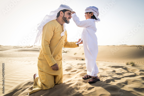 Arabian man and son playing in the desert