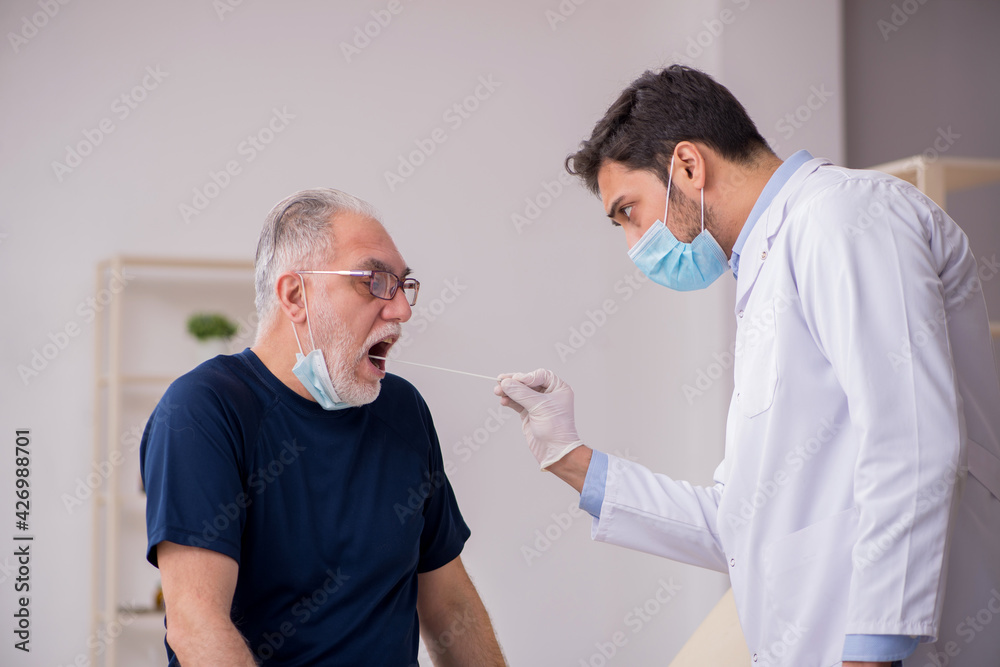 Fototapeta premium Old male patient visiting young male doctor otorhinolaryngologis