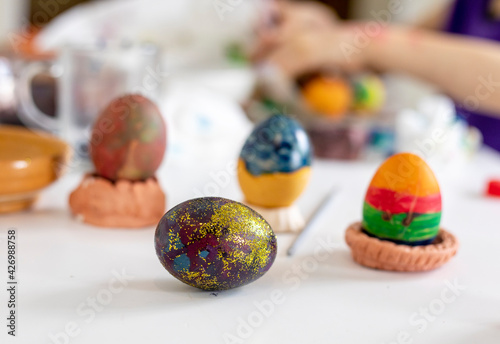 purple easter egg with glitter on the background of painted eggs, preparation for the holiday