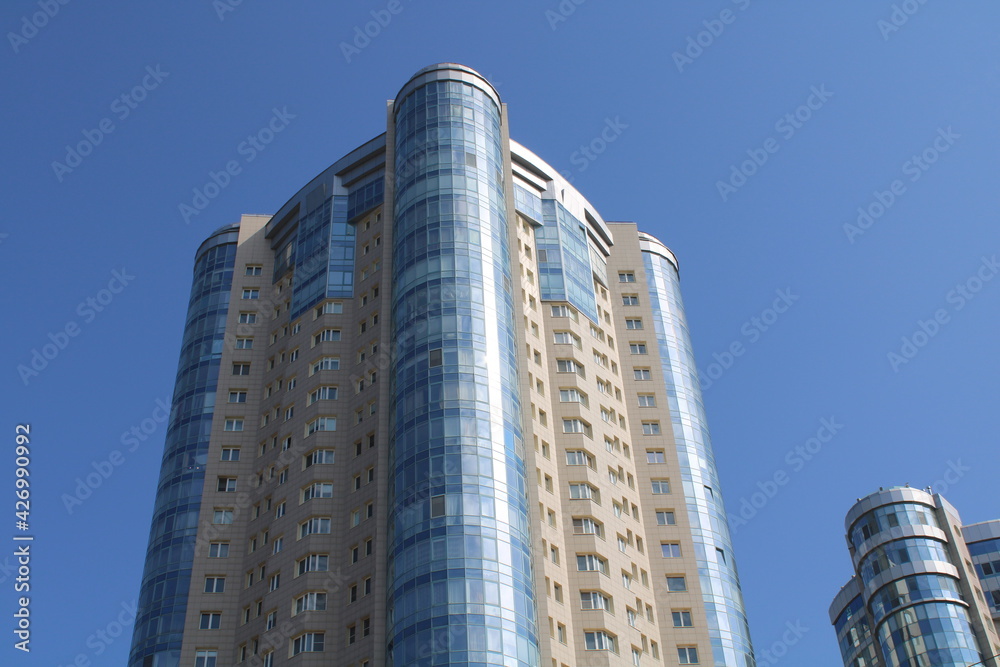 Fototapeta premium the building of a modern skyscraper against the blue sky