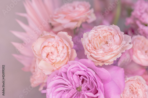 A lush bouquet of light pink  purple  peach colour  white cute delicate small roses of different sizes  flowers. Close-up