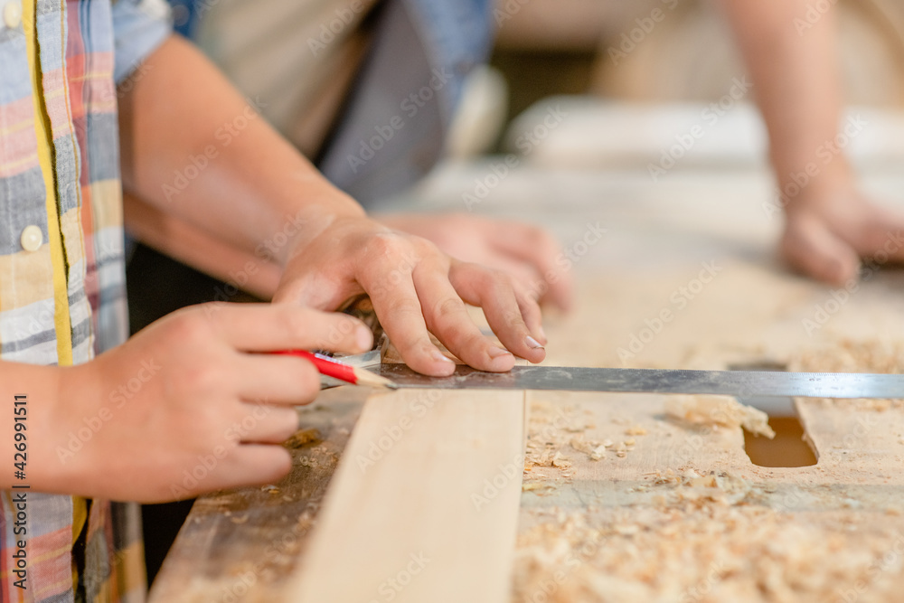Father teaches son carpentry at a workshop Father teaches son carpentry at a workshop