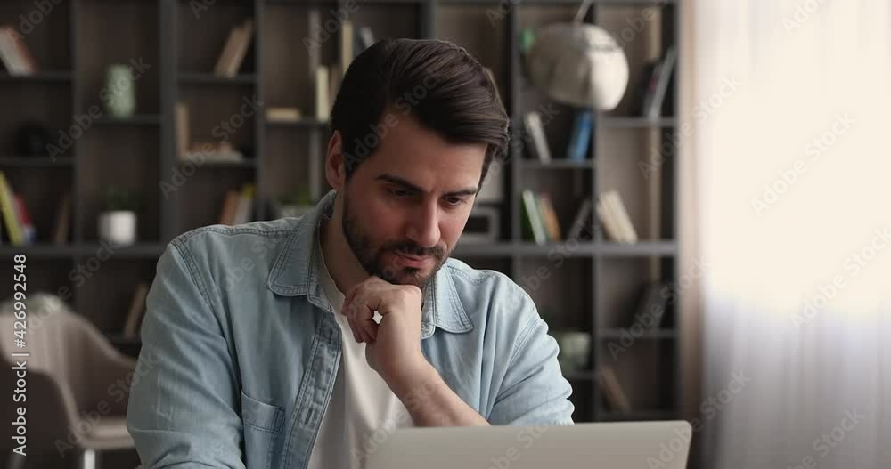 Thoughtful young businessman manager employee looking in distance, thinking on new project development, considering problem solution or searching for inspiration, working on computer at home office.