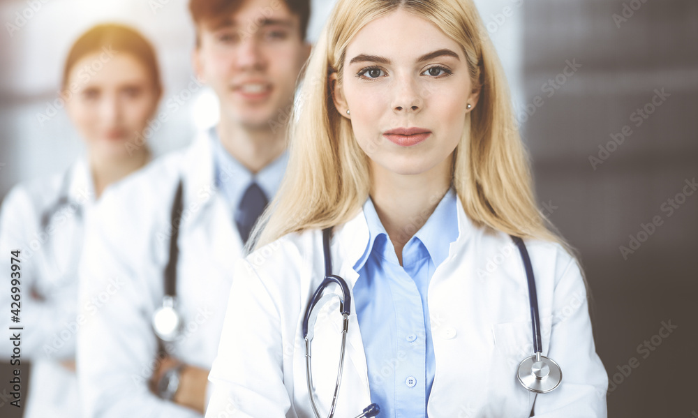 Group of three young doctors standing as a team with arms crossed in modern clinic and ready to help patients. Medicine concept Group of three young doctors standing as a team with arms crossed in modern clinic and ready to help patients. Medicine concept