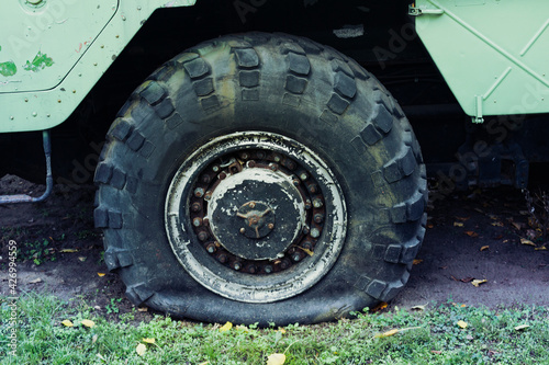Bilde på lerret Close up of a flat tire of a heavy duty military vehicle on field