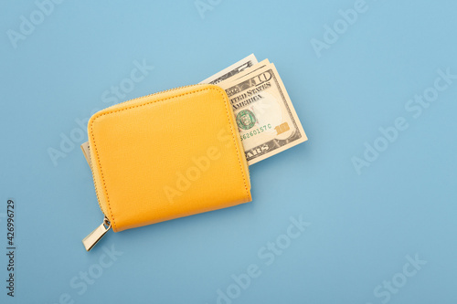 Money in yellow wallet on blue background photo
