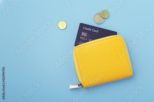 Credit card in wallet with coins on blue background photo