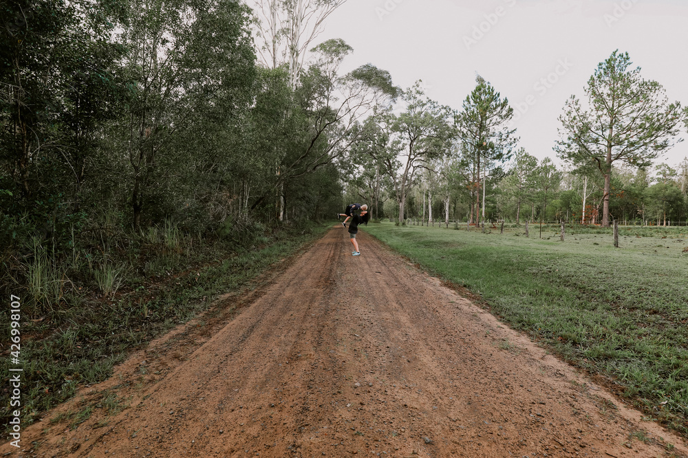 Mother and son playing together on remote country road Mother and son playing together on remote country road