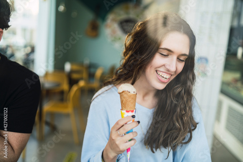 Wallpaper Mural Chica joven tomando helado en cafeteria vista a través de un cristal Torontodigital.ca