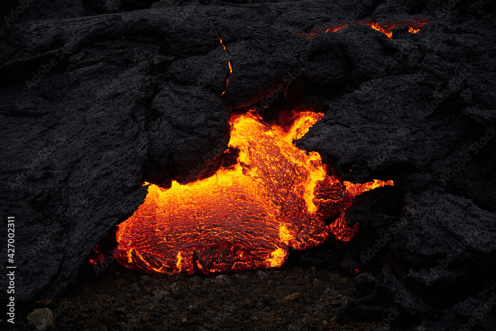 Foto de Magma or melted lava flowing through hardened lava glowing from