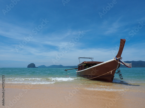 Longtail Thai boat at the beautiful Blue Lagoon with crystal turquoise clear sea water, blue sky and rocks at the background. Amazing Thailand, wild beach with white sands (nobody)