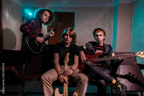 Music and fashion. Group portrait of musicians. Handsome young men holding musical instruments.