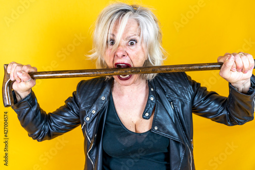 Funny portrait of mature woman. Beautiful lady have fun as a rock star dressed in leather
