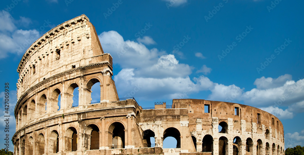 Rome, Italy. Arches archictecture of Colosseum exterior with blue sky background and clouds.