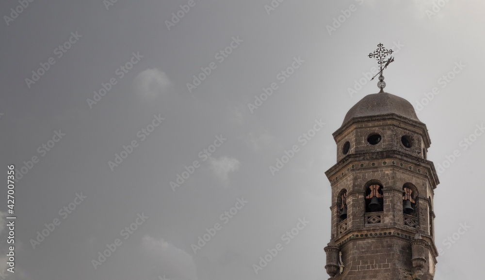 Fototapeta premium Photograph taken of the church tower in Baeza, a World Heritage city, together with an almost clear sky with some small clouds to complete the picture.