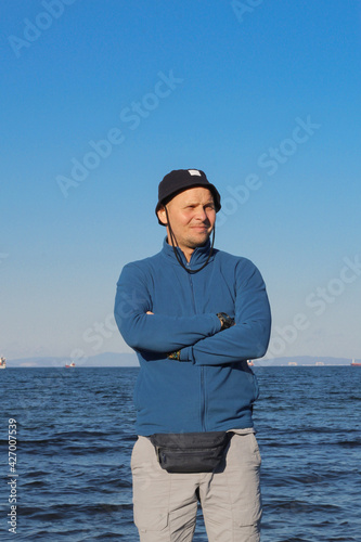 Obraz na płótnie A man in a hat against the backdrop of a seascape. w salonie
