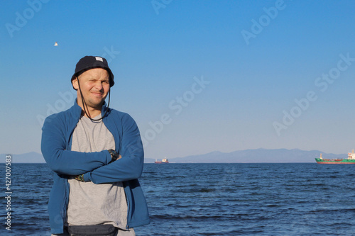 Obraz na płótnie A man in a hat against the backdrop of a seascape. w salonie
