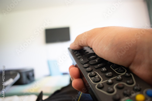 persona con un control remoto en la mano, encendiendo el tv