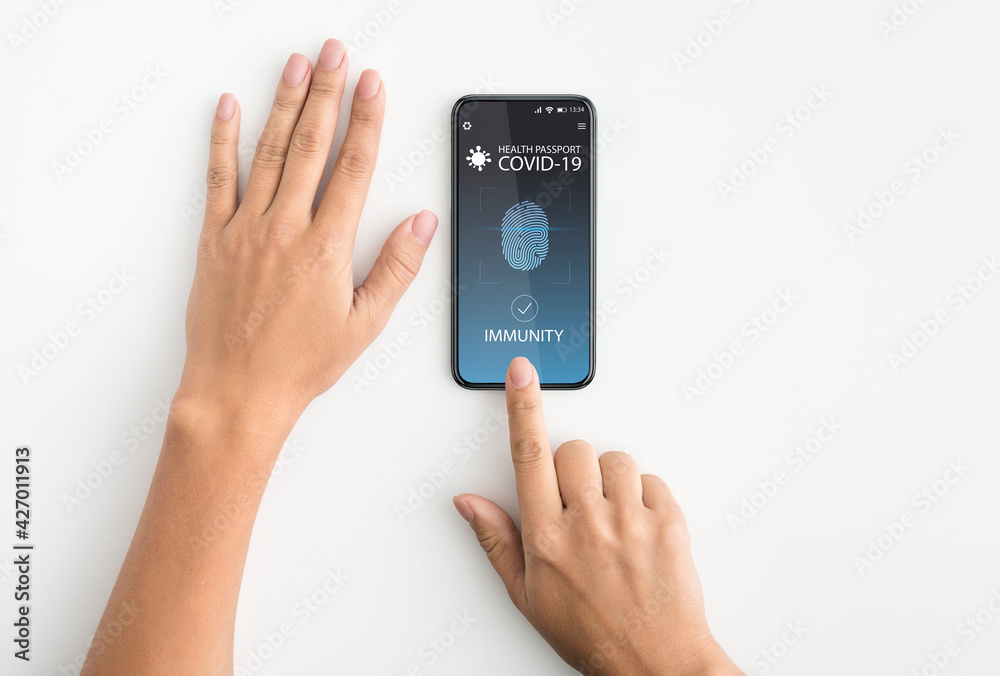 Lady using smartphone with digital immune e-passport for covid-19 Lady using smartphone with digital immune e-passport for covid-19
